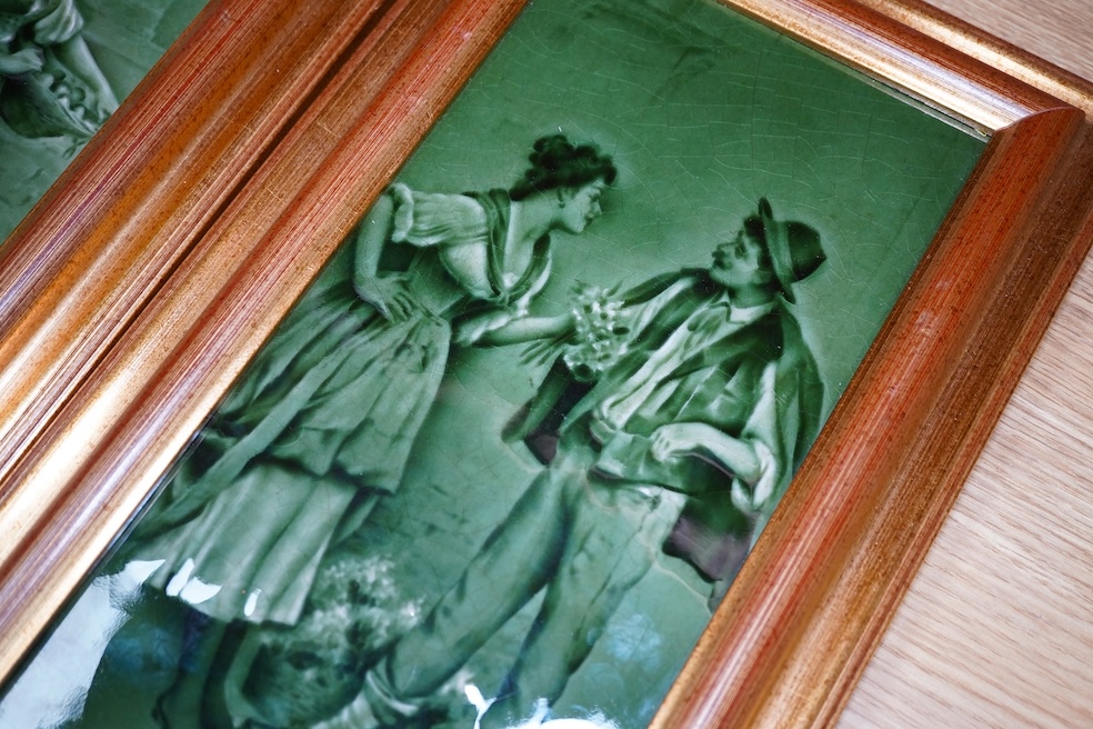 A pair of Craven Dunhill green glazed figurative framed tiles, 29.5cm high, 14cm wide. Condition - good